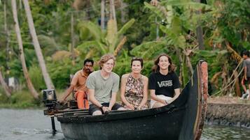 A group of people in a small boat on a river surrounded by lush greenery.