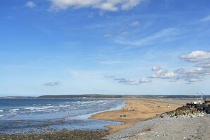 A beach with a rocky shoreline, waves, and a clear sky. - Modern Apartment, Private Parking, Walk to Beach! (Westward Ho)