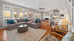 A spacious living room with a large sectional sofa, a coffee table, and a fireplace.