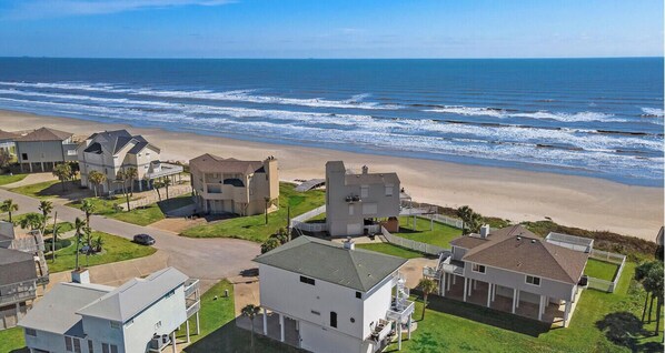 Un quartier résidentiel situé sur la côte, avec des maisons à proximité de la plage, caractérisé par un mélange d’architecture moderne et traditionnelle, et offrant une vue dégagée sur l’océan.