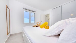 Une chambre d’hôtel avec un lit, une fenêtre, un miroir et une porte.