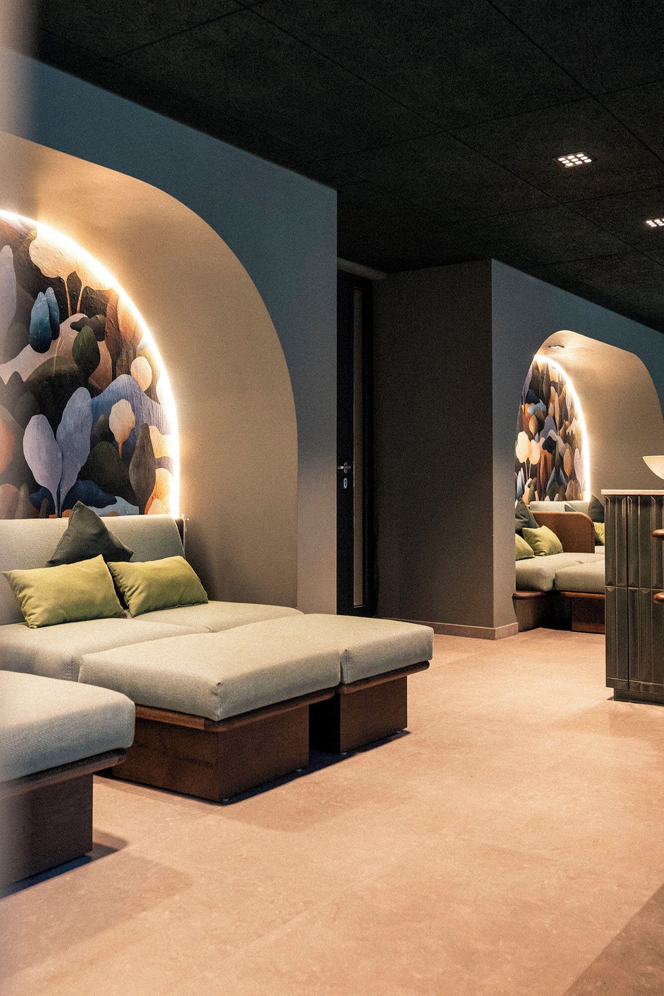 Et moderne afslapningsområde med en sofa og en massagestol, begge med indbygget belysning.