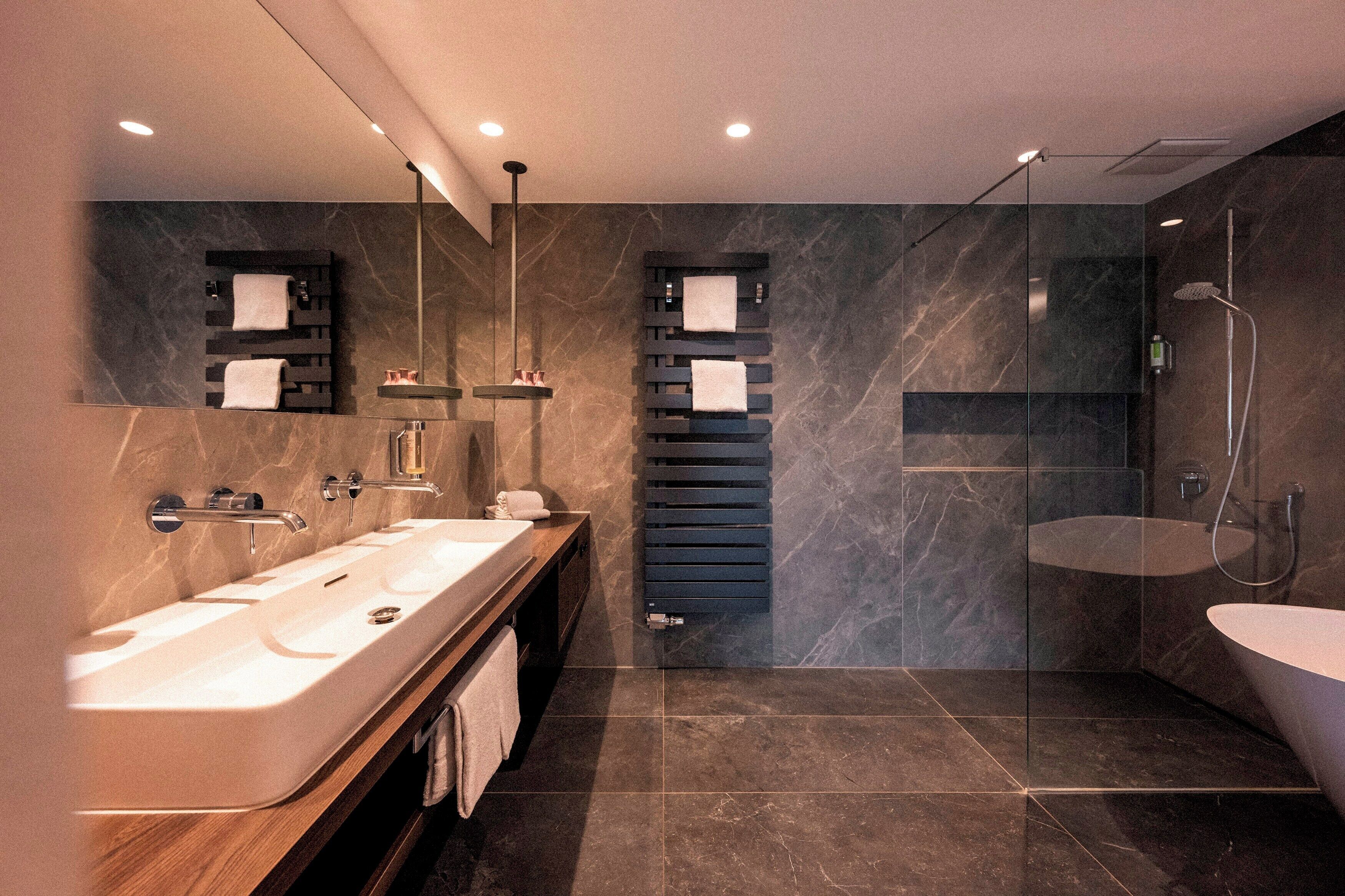 Ein modernes Badezimmer mit einem großen Waschbecken, einer Duschkabine aus Glas und einer separaten Badewanne.