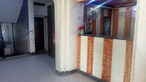A reception area with a check-out counter, a fire extinguisher, and a fan. - Hotel Al Badar (Rawalpindi)