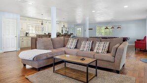 A spacious living area with a sofa, coffee table, and a kitchen in the background. - Wine Country Retreat | Gorgeous Views, Minutes to Wineries (Temecula)