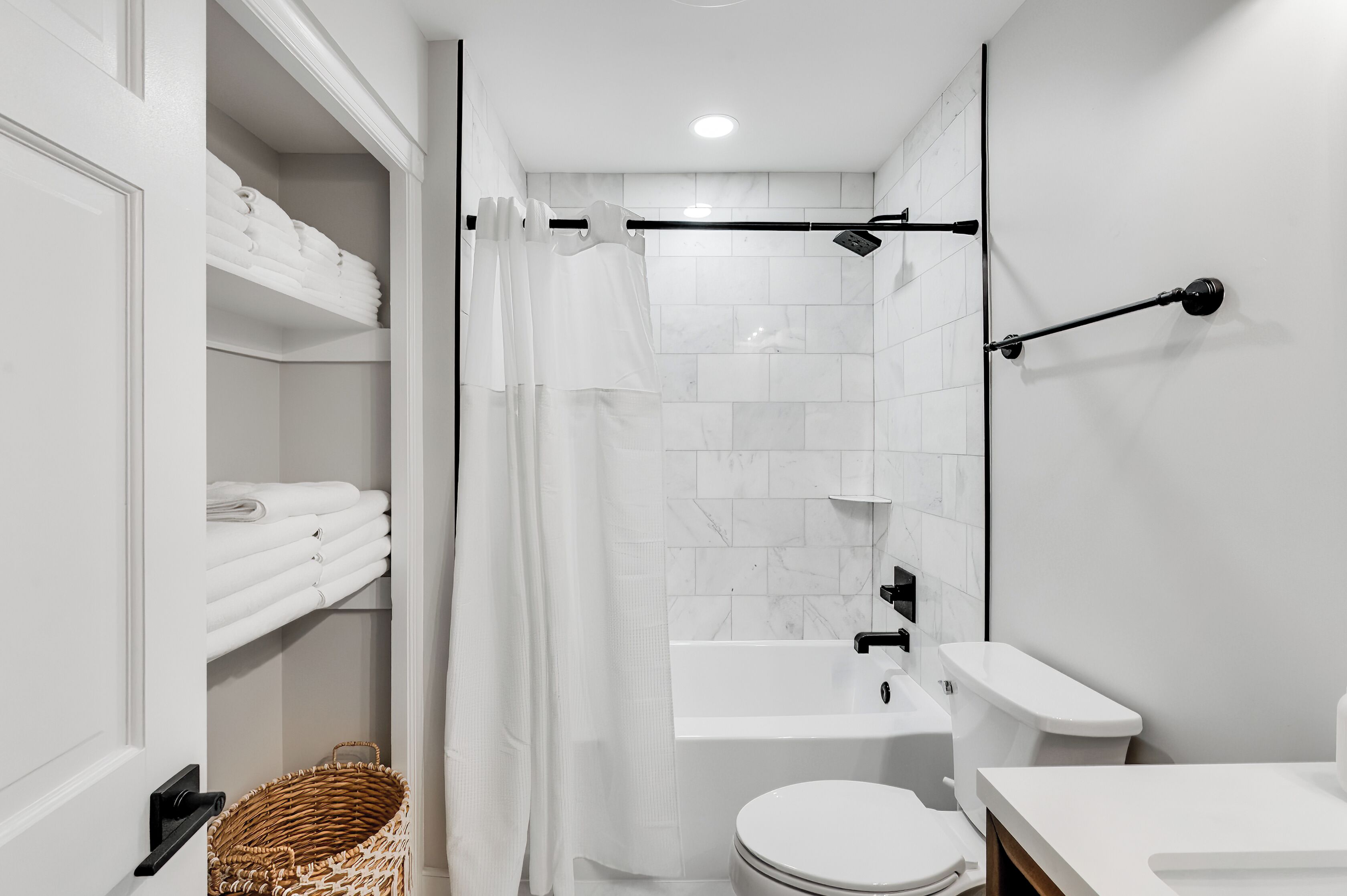 A modern bathroom with a shower, toilet, and sink.