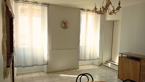 A dining area with a wooden table, chairs, a chandelier, and a clock on the wall. - self-catering apartment for up to 6 people (Cruis)