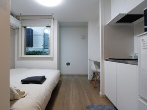 A compact room with a bed, a desk, and a kitchenette. - BE Terrace Nishi-Shinjuku _Shinjuku Area / 5 min. walk from Nishi-Shinjuku Station 6 min. from Shinjuku Station (新宿区)