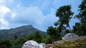 A dome-shaped building surrounded by natural scenery, including a mountain and trees. - Nexstay Karimb Resorts (Thamarassery)
