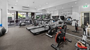 A gym with treadmills, stationary bikes, and weight machines.