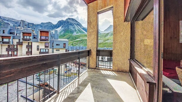 Un balcón con vistas a montañas y edificios.