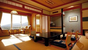 Perinteinen japanilaistyylinen huone, jossa on tatamimatto, matala pöytä ja shoji-liukuovet.