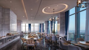 Un'ampia sala da pranzo con soffitti alti, pareti in marmo e grandi finestre che offrono vista sulla città.