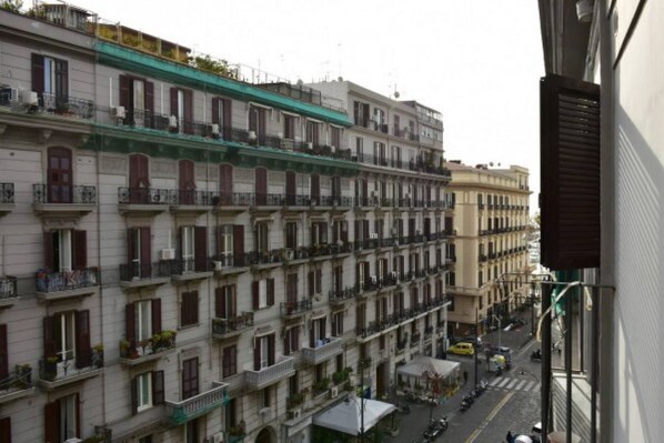 Une rangée d’immeubles à plusieurs étages dotés de balcons, une rue au premier plan et un ciel dégagé.
