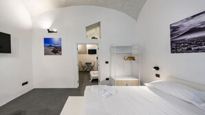Et moderne hotelværelse med en stor seng, et siddeområde og udsigt over byen.