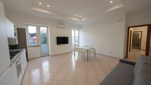 Un appartement moderne comprenant une cuisine, un coin repas et un salon.