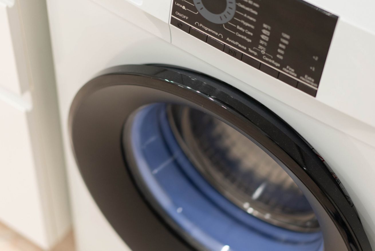 A front view of a washing machine with a control panel displaying various settings.