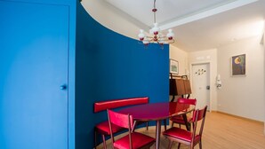 A dining area with a red table and chairs, a chandelier, and a blue accent wall. - Da Luca e Laura by Dimorra (Napoli)