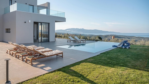 A modern house with a pool, sun loungers, and a view of the sea. - Villa Levante With Sea View (Platanias)