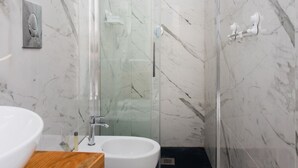 A modern bathroom with a glass shower enclosure, a white sink, and a marble backsplash. - Dimora al Cristo Velato By Dimorra (Napoli)