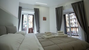 A modern hotel room with a large bed, a balcony with curtains, and a city view. - New Corte 2 By Dimorra (Napoli)
