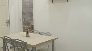 A dining area with a table, chairs, and a vase.