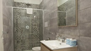 A modern bathroom with a shower, toilet, and sink.
