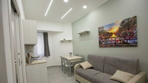 A compact living space with a kitchenette, dining area, and a sofa. - New Corte 6 By Dimorra (Napoli)