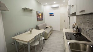 A compact kitchen with a dining area, a sofa, and a small table. - New Corte 6 By Dimorra (Napoli)