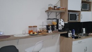 A kitchenette with a coffee maker, microwave, and various food items on the counter. - Dimorra Boutique room 2 (Napoli)