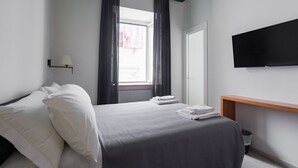 A modern hotel room with a bed, a TV, a window with curtains, and a bedside table. - Weaver Suites 3 By Dimorra (NAPOLI)