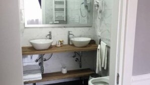 A modern bathroom with two sinks, a toilet, and a mirror. - Dimorra Boutique room 3 (Napoli)
