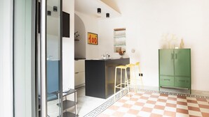 Een moderne keuken met een zwart eiland, een groene kast en een zwart-wit geruite vloer.