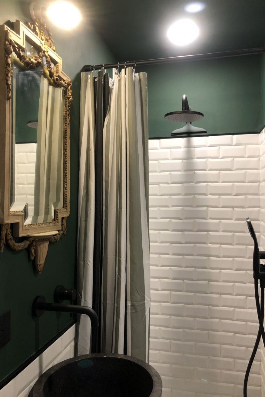 Een badkamer met een spiegel, een douchegordijn, een wastafel en een handdoekrek.