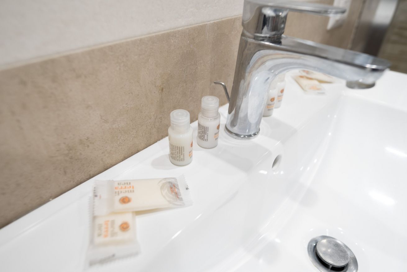 A bathroom sink with toiletries and a faucet.