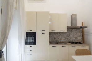 Réfrigérateur, un four, cafetière-théière, vaisselle et ustensiles