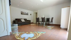 En moderne stue med sofa, spisebord og stole.