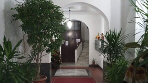 A hallway with a red carpet, potted plants, and a staircase leading to an upper level. - La Casa di Giulia By Dimorra (Napoli)