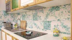 A kitchen with a white countertop, a toaster, a sink, and a microwave.