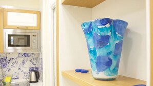 A kitchen with a microwave, a sink, and a blue vase on a shelf. - King Ferdinando IV by Dimorra (Napoli)