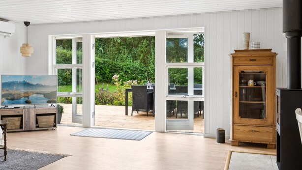 A spacious living room with a large sliding glass door leading to an outdoor patio.