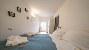 A hotel room with two beds, a view to the outside, and a door leading to a hallway. - Andreas Home By dimorra (Napoli)