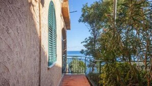 A narrow pathway leading to a balcony with a view of the sea.