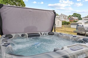 A hot tub with a cover, surrounded by a residential area with houses and a barbecue grill in the background. - Modern Farmhouse w/ Hot Tub, Close to SNP (Shenandoah)