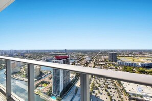 A high-rise building with a clear view of a cityscape, including a river and a parking area.