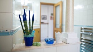 A bathroom with a sink, a mirror, and a towel rack. - Suite Orchidea by Dimorra (Napoli)