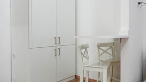 A white wardrobe with two doors and a small table with two chairs. - Neapolitan Soul 1 By Dimorra (Napoli)