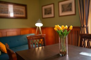 Una mesa de comedor con un florero de vidrio transparente que contiene tulipanes amarillos.