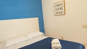 A neatly made bed with blue and white bedding, a folded towel on the bed, and a sign on the wall that reads "ALWAYS KISS ME GOOD NIGHT". - Star in Toledo By Dimorra (Napoli)