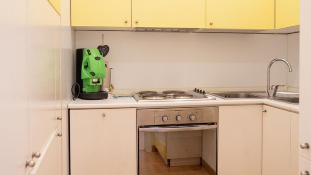 A compact kitchen with a gas stove, a built-in oven, and a sink. - Star in Toledo By Dimorra (Napoli)
